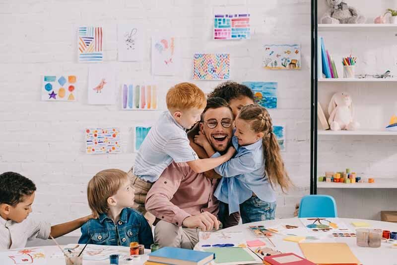 eine Frau und zwei Kinder sitzen an einem Tisch mit einem Buch