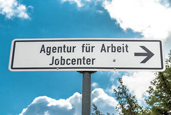 ein Wegschild für die Agentur für Arbeit/Jobcenter mit einem Himmel Hintergrund