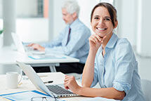 eine Frau sitzt an einem Schreibtisch mit einem Laptop