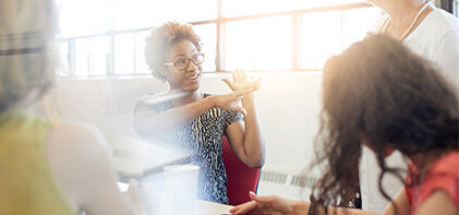 eine Gruppe von Menschen, die um einen Tisch sitzen