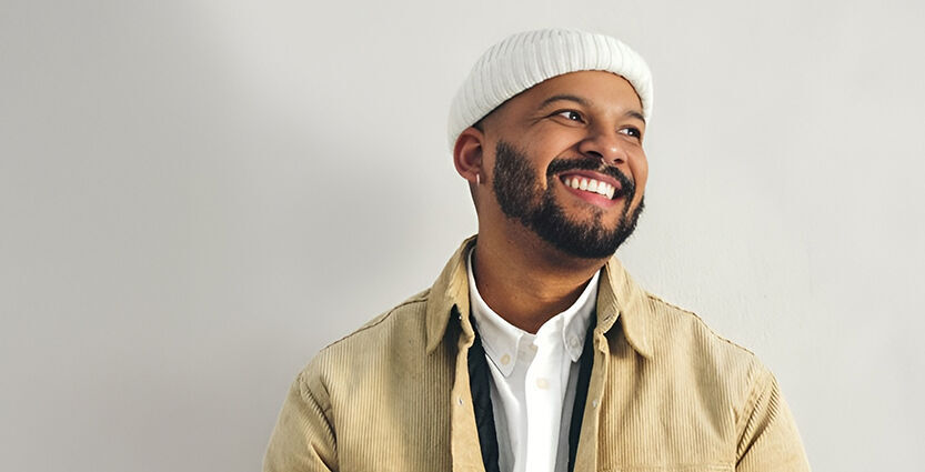 Junger Mann blickt lächelnd zur Seite